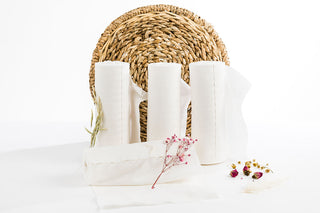 4 refill rolls of Wild & Pure dry wipes with a woven mat standing behind them
