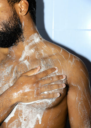 Man using foaming body wash in the shower